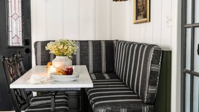 Parisian bistro style breakfast nook decor with banquette bench, marble and cast iron table, and chinoiserie bamboo dining chairs