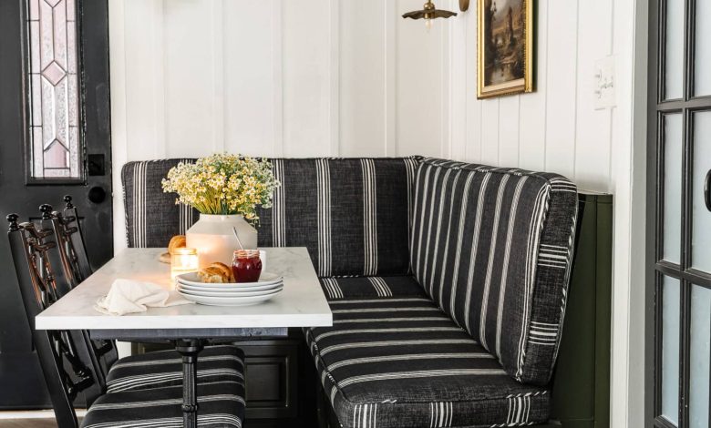 Parisian bistro style breakfast nook decor with banquette bench, marble and cast iron table, and chinoiserie bamboo dining chairs