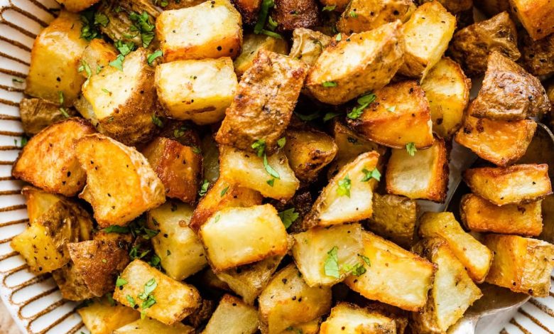 Roasted potatoes garnished with fresh parsley in a bowl.