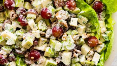 A Waldorf salad with sliced apples and grapes served on a bed of lettuce.