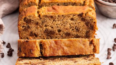 Multiple slices of coconut flour banana bread lean against one another near the loaf of bread.