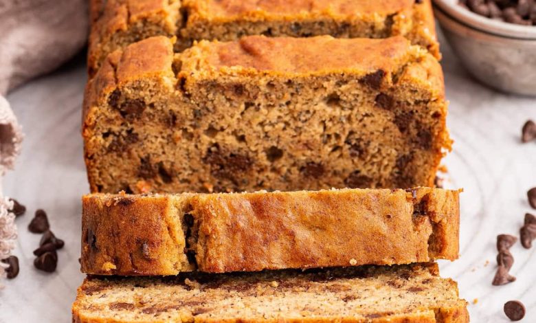 Multiple slices of coconut flour banana bread lean against one another near the loaf of bread.