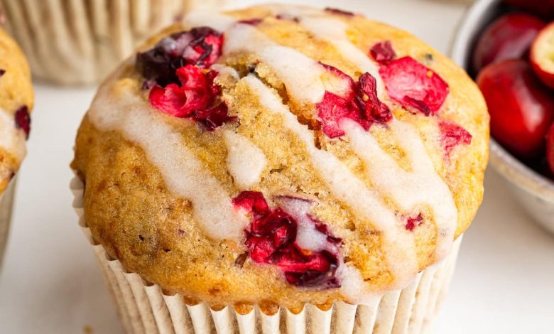 A cranberry orange muffin topped with a drizzle of an almond milk based glaze.