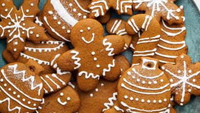 Multiple gingerbread cookies decorated with icing on a plate.