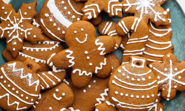 Multiple gingerbread cookies decorated with icing on a plate.