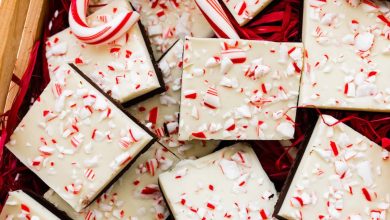 Square peppermint bark pieces stacked on top of each other in a gift box.