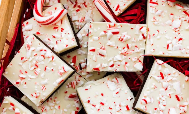 Square peppermint bark pieces stacked on top of each other in a gift box.