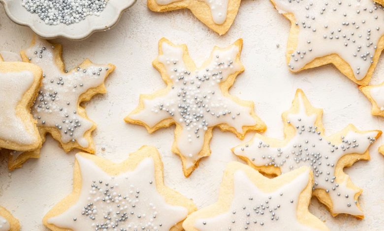 Multiple gluten free sugar cookies decorated with icing and sprinkles.