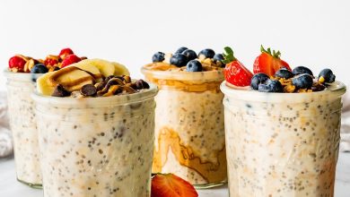 Four glass jars of overnight oats topped with fresh berries.