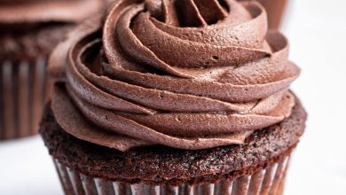 Three chocolate cupcakes topped with chocolate buttercream frosting.