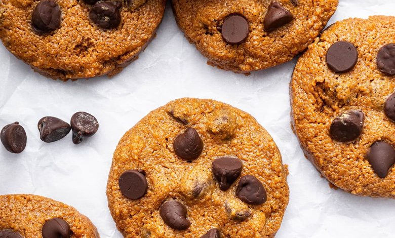 9 flourless peanut butter cookies with chocolate chips spread out on parchment paper.