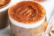 A glass cup of tiramisu chia pudding topped with cocoa powder.