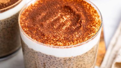 A glass cup of tiramisu chia pudding topped with cocoa powder.