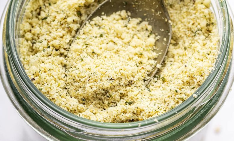 A vegan parmesan cheese made with hemp seeds in a glass mason jar with a metal spoon.