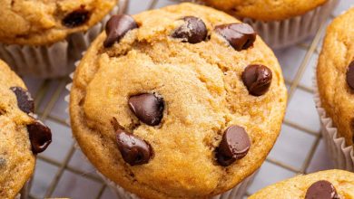 Kodiak cake muffins with chocolate chips on top, cooling on a wire rack.