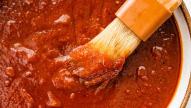 A bowl filled with homemade BBQ sauce with a small brush in the sauce.