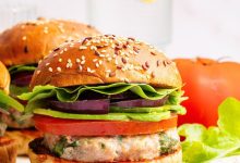 A spinach feta turkey burger served on a seeded bun with tomato, lettuce, red onion and avocado.