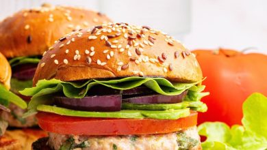 A spinach feta turkey burger served on a seeded bun with tomato, lettuce, red onion and avocado.