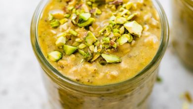 A jar of pistachio overnight oats topped with chopped pistachios.