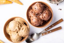 Two bowls of protein ice cream-one is chocolate and one is vanilla. There are two spoons next to the bowls.