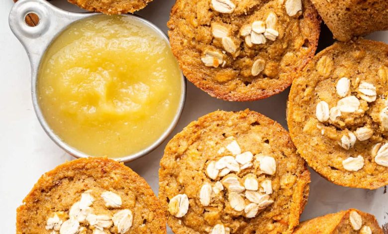 Baked applesauce muffins arranged with a small bowl of applesauce